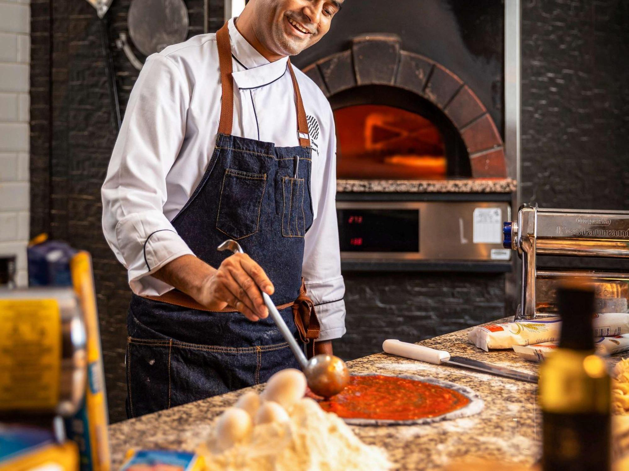 Pullman Dubai Jumeirah Lakes Towers Bagian luar foto A pizzaiolo preparing a pizza