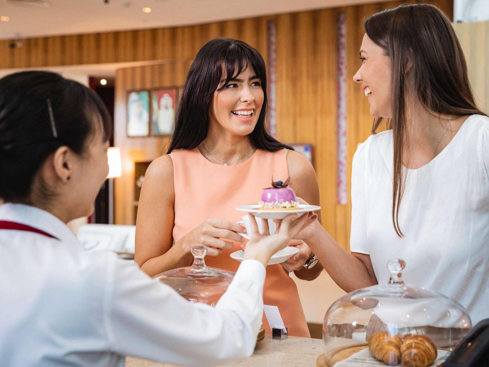 Pullman Dubai Jumeirah Lakes Towers Bagian luar foto A guest being served at the lounge